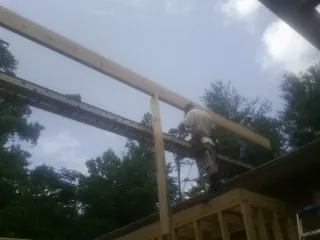 Carpenter setting a ridge beam over a new addition frame — Ice Dam Removal by Roofing Brothers in Varna