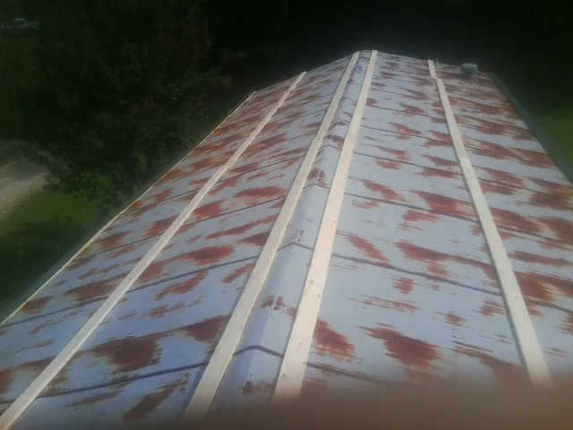Rusted metal roof panels with new wood purlins before replacement — Storm Damage Roof Repair in Varna by Roofing Brothers