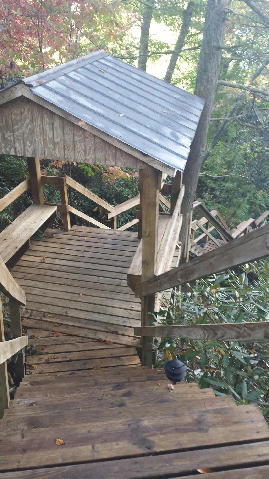 Metal roofed shelter over wooden steps on a wooded walkway — Skylight Repair & Installation work by our crew in Varna
