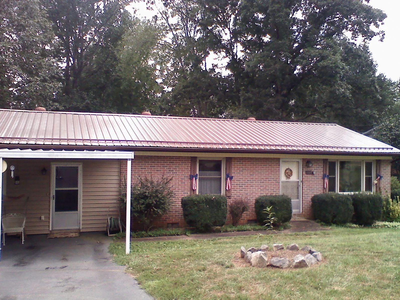 Bronze metal roof and carport on a brick ranch home — Roof Repair work by our crew in Varna